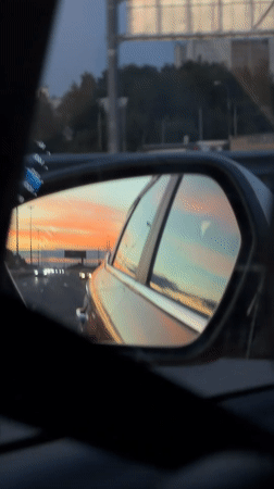 Sunset reflected in a side mirror on a Moscow road