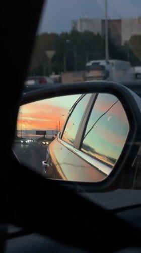 Sunset reflected in a side mirror on a Moscow road