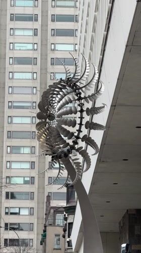 Kinetic sculpture with rotating metallic elements observed in Montreal