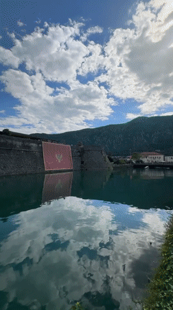 Tourists explore historic Kotor waterfront and mountain walls