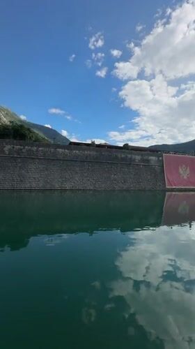 Tourists explore historic Kotor waterfront and mountain walls