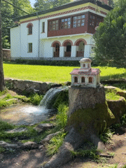 Visitor documents Bulgarian monastery grounds and stream features