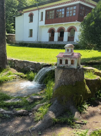 Visitor documents Bulgarian monastery grounds and stream features