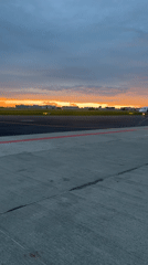 Golden sunset over Warsaw airport, seen from tarmac and wing