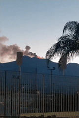 Volcano erupts at twilight, dark smoke and lava visible