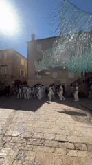 White-uniformed marching band performs in Budva's historic square