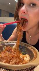 Woman dines with chopsticks at Pudong restaurant