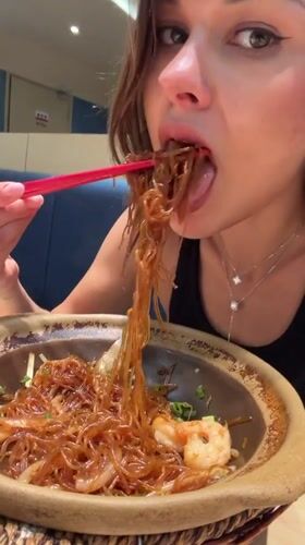 Woman dines with chopsticks at Pudong restaurant