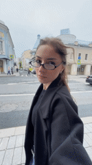 Woman walks Moscow sidewalk during morning commute