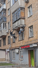 Workers paint building exterior using ropes in Khimki