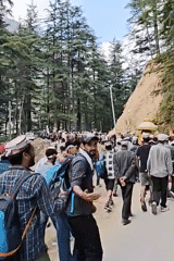 Traditional procession moves through mountainous road near Dunkharamul, India