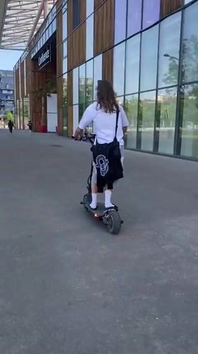 Young man performs scooter tricks on Lyon walkway