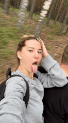Woman makes faces at camera during forest journey in Russia