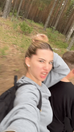 Woman makes faces at camera during forest journey in Russia