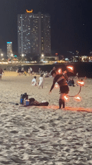 Fire hoop performer practices acrobatics on Nha Trang beach