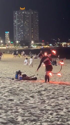 Fire hoop performer practices acrobatics on Nha Trang beach