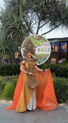 Woman poses in traditional Balinese costume at Denpasar sign