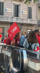 Red-shirted group with flags gathers near Barcelona escalator