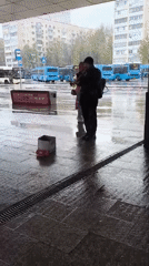 Street musician plays trumpet in rain, Khimki Russia