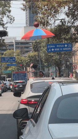Street performer juggles from SUV sunroof during Mexico City traffic