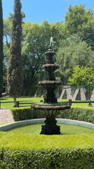 Woman photographs with dog at garden fountain in Mexico