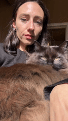 Woman enjoys spring moment with cats, tulips in Petersburg garden