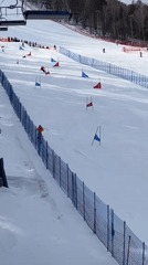 Snowboarders attempt rail tricks at ski resort terrain park