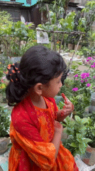 Girl in traditional dress tends garden in Dhaka