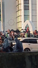 Street activity outside a modern building in Surabaya