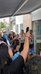 Colorful crowd celebrates outside building in Wilde, Argentina