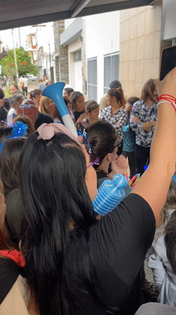 Colorful crowd celebrates outside building in Wilde, Argentina