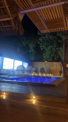 Nighttime pool lounge venue captured with blue lighting, stage