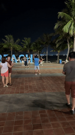 Couples dance on Đà Nẵng beach promenade at night