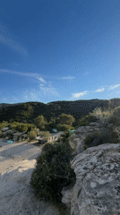 Person enjoys scenic cliff-top view at Greek coastal location