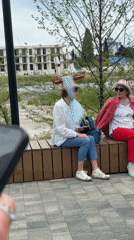 Two women sit on bench in Sochi