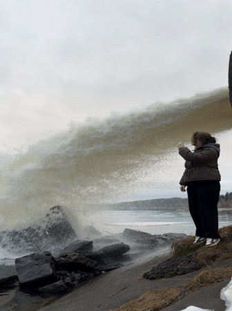 Woman photographs herself at Chernushka waterfall during afternoon visit