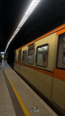 Yellow subway train departs Sofia station platform