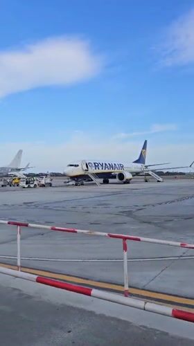 Passengers board aircraft at Reus Airport under sunny skies
