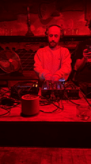 DJ performs at London venue under red lighting