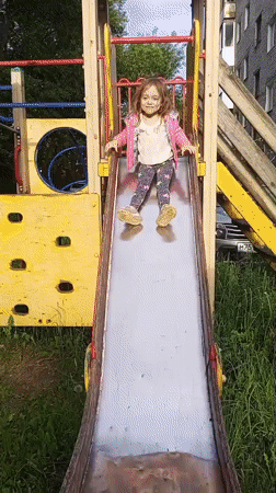 Child plays at playground amid spring blooms in Berezniki