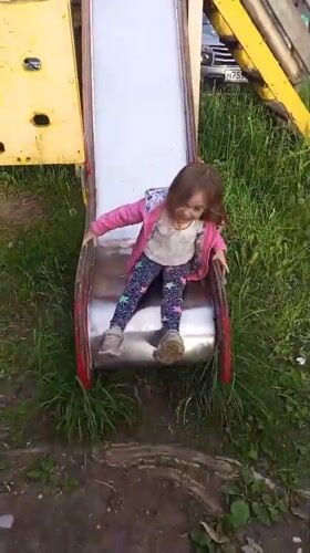 Child plays at playground amid spring blooms in Berezniki