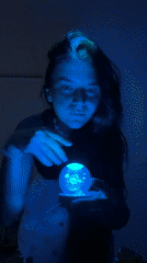 Woman holds glowing orb in dark room in Vietnam