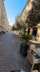 Cycling through cobblestone streets in Trento, Italy