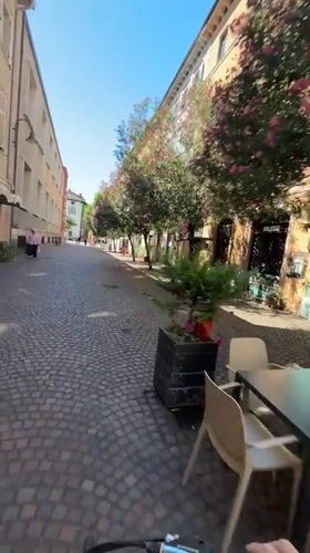 Cycling through cobblestone streets in Trento, Italy