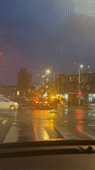Driver waits at red light during rainy evening