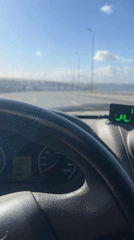 Driver crosses Sankt-Peterburg bridge on sunny morning, temperature 3 degrees
