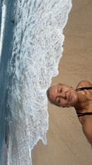 Beach selfie session with waves and a clifftop backdrop