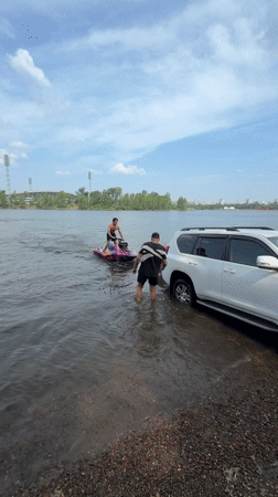 Custom jet ski and submerged SUV on a Krasnoyarsk riverbank