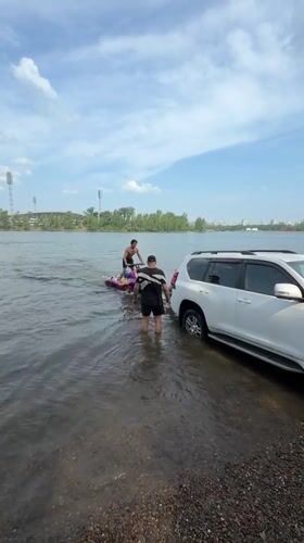 Custom jet ski and submerged SUV on a Krasnoyarsk riverbank