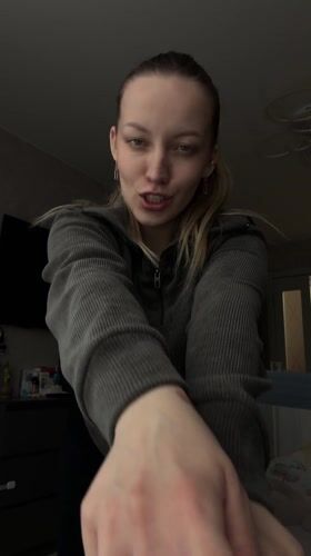 Woman recorded smiling, gesturing cheerfully indoors in Reshetnikovo
